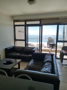 a living room with couches and a view of the ocean at Point Village Accommodation - Santos 40 in Mossel Bay