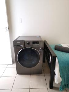 a tv sitting on the floor next to a bed at Point Village Accommodation - Santos 40 in Mossel Bay