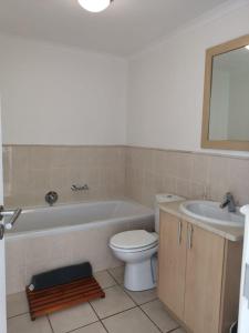 a bathroom with a tub and a toilet and a sink at Point Village Accommodation - Santos 40 in Mossel Bay