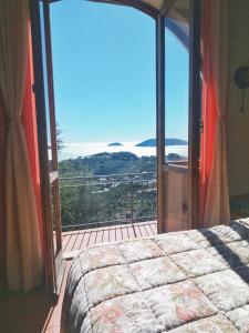 レーリチにあるAi Canarbin - colline di Lericiのベッドルーム1室(バルコニーに面した大きなガラスドア付)