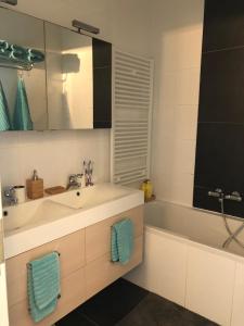 een badkamer met een wastafel en een bad bij Seawind in Knokke-Heist