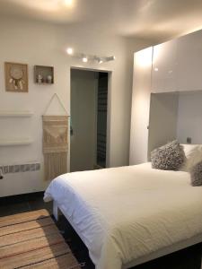 sypialnia z dużym białym łóżkiem i lustrem w obiekcie Seawind w mieście Knokke-Heist
