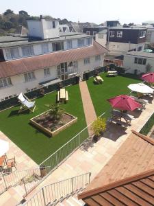 an aerial view of a yard with tables and umbrellas at The Riviera Hotel & Apartments - Alum Chine in Bournemouth