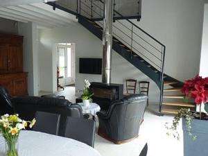 - un salon avec des chaises noires et un escalier dans l'établissement Jolie Maison de Campagne en pierre de tuffeau, à Longué
