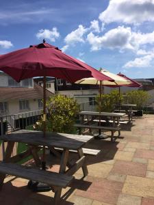 a group of picnic tables with umbrellas on a patio at The Riviera Hotel & Apartments - Alum Chine in Bournemouth
