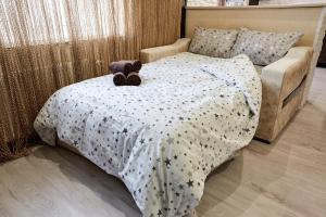 a teddy bear sitting on a bed in a bedroom at Babylon Apartments on Vidinska in Rivne