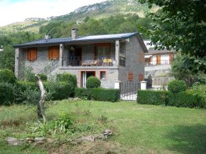 une maison en pierre avec un balcon dans une cour dans l'établissement Appartement les rives de l’Ariège, à Luzenac