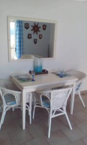 a white table with chairs and a mirror at Glyfada Corfu Apartment in Glyfada