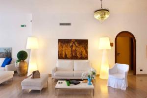a living room with white furniture and a painting on the wall at Hotel Rivage in Sorrento