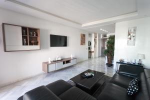 sala de estar con sofá y TV en la pared en La Siesta Beach Resort, en Mohammedia