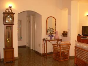 a room with a clock and a table and a mirror at Hotel Il Piccolo Golf in Porto Cervo