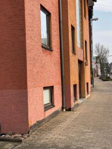 ein rotes Backsteingebäude mit zwei Fenstern auf einer Straße in der Unterkunft OG Mitte 108A 2 Zimmer Apartment in Holzminden