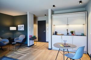 a living room with a table and chairs and a kitchen at ipartment Wolfsburg in Wolfsburg