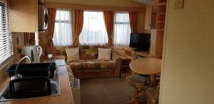 a small living room with a couch and a table at 4 Berth with private Garden - 58 Brightholme Holiday Park Brean! in Brean