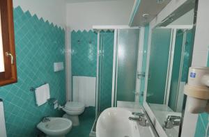 a green bathroom with a toilet and a sink at Hotel Il Piccolo Golf in Porto Cervo