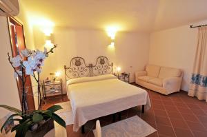 a bedroom with a bed and a couch in a room at Hotel Il Piccolo Golf in Porto Cervo