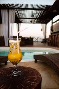 una bebida sentada en una mesa junto a una piscina en Pousada Portal da Ilha en Itarema
