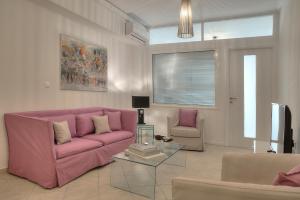 - un salon avec un canapé rose et une table en verre dans l'établissement Downtown Glyfada smart apartment, à Athènes