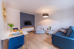 a living room with two blue chairs and a table at Beautiful Sopot Apartment 600 m to the Beach by Renters in Sopot
