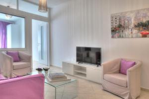- un salon avec deux chaises et une télévision dans l'établissement Downtown Glyfada smart apartment, à Athènes