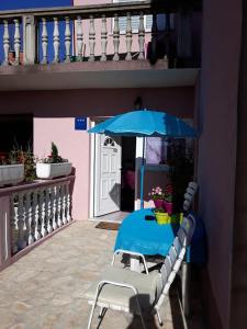 une table bleue avec une chaise et un parasol dans l'établissement Studio apartman"Mirjana", Podhum 368, à Podhum