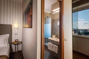 una camera da letto con bagno dotato di lavandino e specchio di Best Western Hotel Piccadilly a Roma