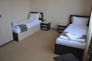 Un pat sau paturi într-o cameră la Alexander Hotel