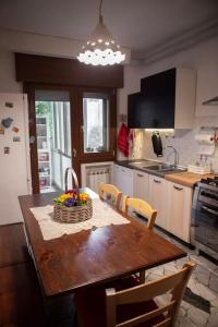 a kitchen with a wooden table with chairs and a kitchen with a sink at Casa Carlotta in Mestre