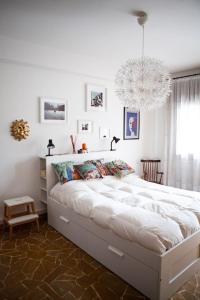 una camera con un grande letto e un lampadario a braccio di Casa Carlotta a Mestre