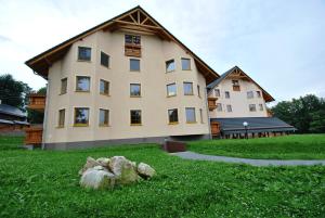 a large house with some rocks in the grass at Apartamenty Sun Seasons 24 - Panorama in Karpacz