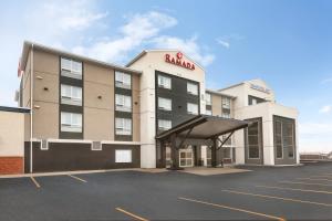 a hotel with a parking lot in front of it at Ramada by Wyndham Airdrie Hotel & Suites in Airdrie