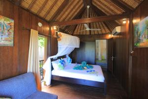 1 dormitorio con 1 cama y 1 silla azul en Villa Rinisha Rumah Senja Temukus Lovina, en Lovina