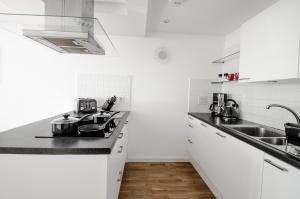 - une cuisine blanche avec évier et cuisinière dans l'établissement Orange Apartments Polmuir Gardens Only 7 minutes to City Centre, à Aberdeen