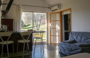 cocina y sala de estar con mesa y sofá en San-Val' Eau, en Froideterre