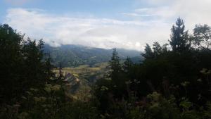a view of a mountain range with trees and clouds at Oasis in Aspindza