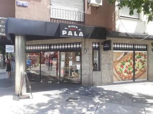 una pizzería con un cartel en la parte delantera en Aquí Departamentos en Buenos Aires