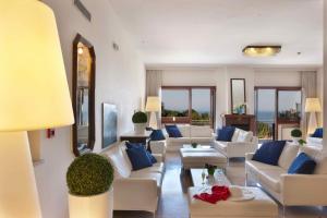 a living room with white couches and blue pillows at Hotel Rivage in Sorrento