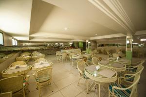 a restaurant with tables and chairs and a counter at Estação do Sol Praia Hotel in Porto De Galinhas
