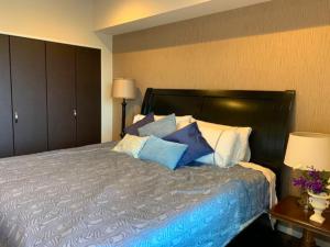 a bedroom with a bed with blue and white pillows at Ocean Resort House 205 in Onna