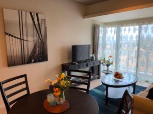 a living room with a television and a table and chairs at Ocean Resort House 205 in Onna