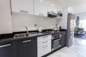 a kitchen with white cabinets and a stainless steel refrigerator at La Siesta Beach Resort in Mohammedia