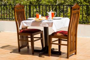 a table with a plate of food and two chairs at Sakura Villa Bentota in Bentota