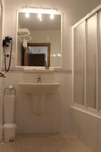 a bathroom with a sink and a mirror and a toilet at Apartamentos La Lula in Cudillero