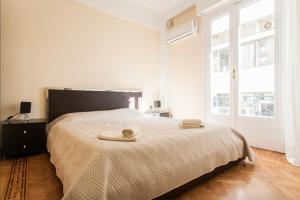 een slaapkamer met een groot bed en 2 handdoeken bij Beautiful Apartment at Plaka in Athene