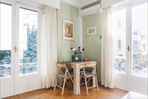 a dining room with a table and chairs and windows at Beautiful Apartment at Plaka in Athens