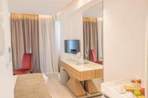 a hotel room with a desk and a mirror at Kokkinos Boutique Hotel in Protaras