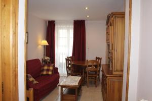 a living room with a red couch and a table at Apartamentos La Lula in Cudillero