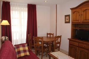 a living room with a dining room table and a bedroom at Apartamentos La Lula in Cudillero