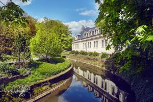 ein Gebäude neben einem Fluss vor einem Gebäude in der Unterkunft Villa Welcome in Mondorf-les-Bains