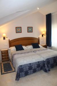 a bedroom with two beds with blue and white sheets at Apartamentos La Lula in Cudillero